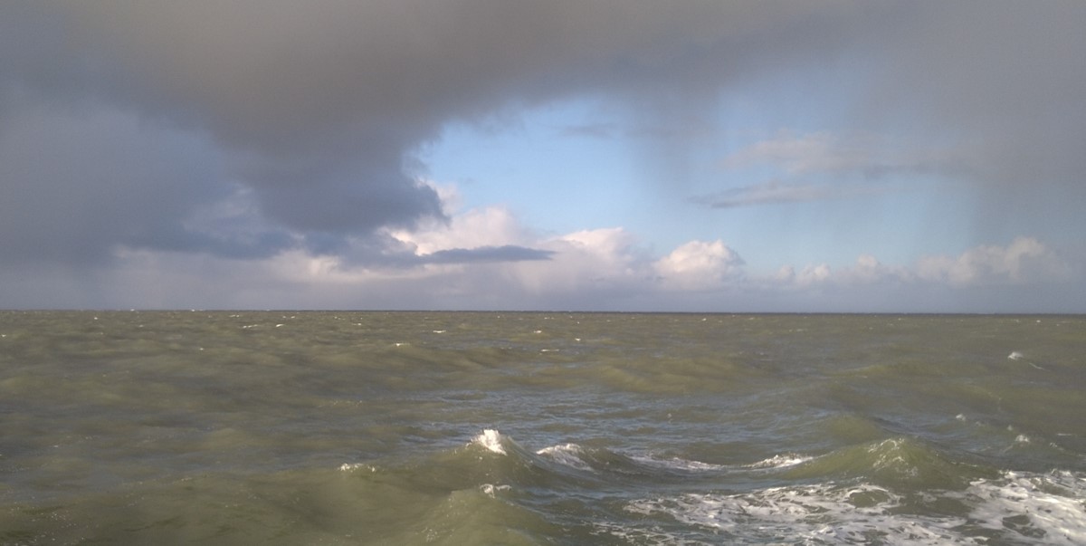 A typical Dutch seascape with clouds, blue skies and a green North Sea A typical Dutch seascape with clouds, blue skies and a green North Sea