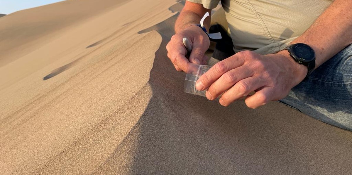 Sampling aeolian transport; particles that 'fly' over the dune (image credit: Catarina Guerreiro) Sampling aeolian transport; particles that 'fly' over the dune (image credit: Catarina Guerreiro)