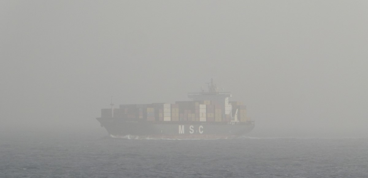 A container ship suddenly pops up from the dust-fog A container ship suddenly pops up from the dust-fog